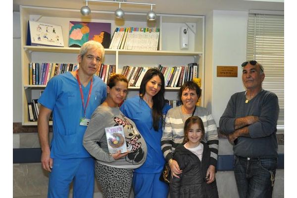 בתמונה – הצוות, היולדת ומשפחת בת חן בספריה