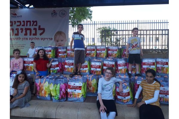 בתמונה - מכינים חבילות למשפחות נזקקות