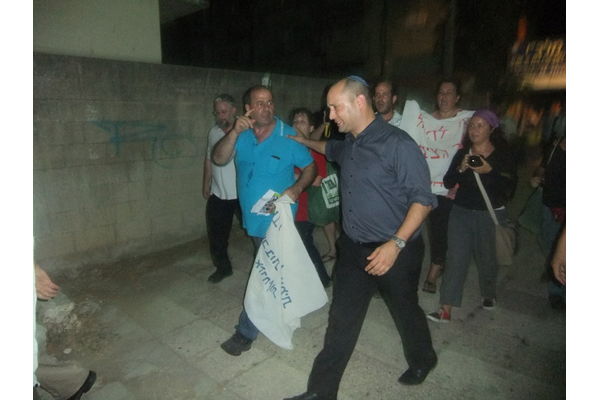 השר נפתלי בנט ברחוב מוקף באנשי המחאה